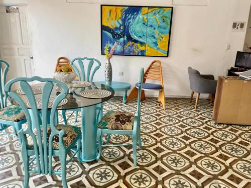 uma sala de jantar com uma mesa e cadeiras num piso de azulejo em Hostal Badillo SV em Cartagena das Índias