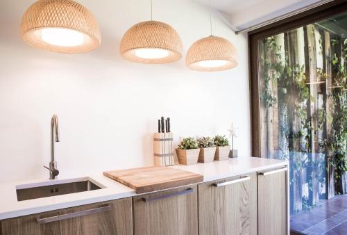 a kitchen with a sink and two lights at Beach House Pedras D'el Rei in Santa Luzia