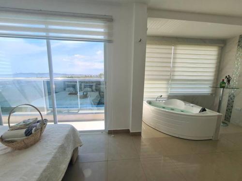 un ampio bagno con vasca e un balcone. di Ecusuites Playas Suite 3 Preference Balcón & Jacuzzi Vista al Mar a Playas