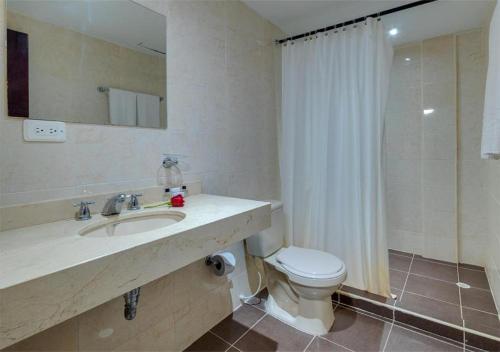 La salle de bains est pourvue d'un lavabo, de toilettes et d'une douche. dans l'établissement Hotel Dorado Plaza Punta Arena, à Tierra Bomba