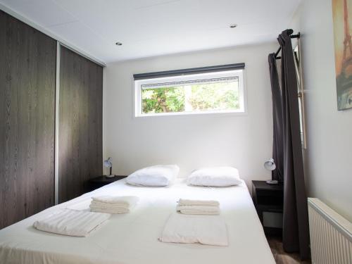 En eller flere senge i et værelse på Spacious house with covered terrace, located on a holiday park in Rhenen