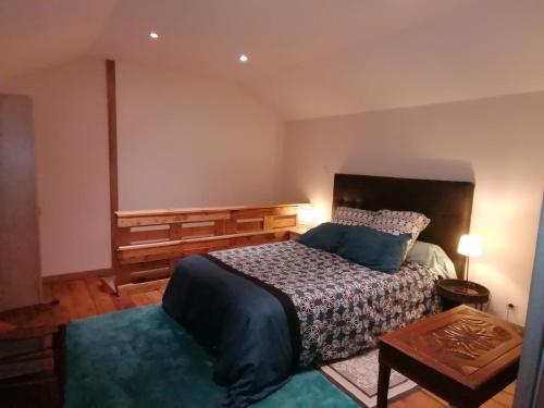ein Schlafzimmer mit einem Bett und einem Tisch darin in der Unterkunft Le Garni Vendémiaire in Vesoul