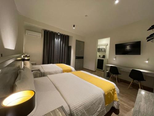 Habitación de hotel con 2 camas y TV de pantalla plana. en Capital Suites, en Chilpancingo 