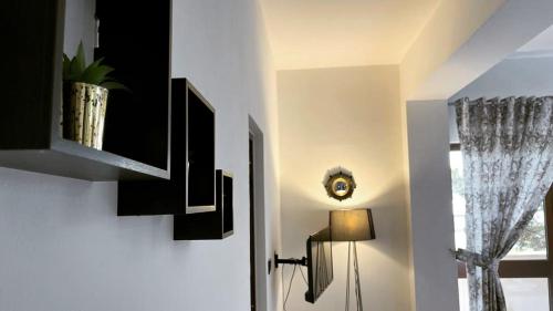a hallway with black cabinets and a lamp and a window at Hotel Ambasador Garden in Lezhë