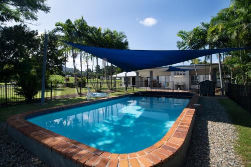 a swimming pool with a mosquito net over it at Apartments at Mission Beach in Mission Beach