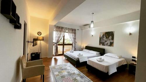 una habitación de hotel con dos camas y una silla en Hotel Ambasador Garden, en Lezhë