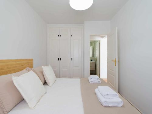 una camera bianca con un letto con due asciugamani di Mahostly Bungalow Vista Golf a Caleta De Fuste