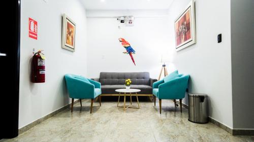 a living room with a couch and two chairs at Hotel Boutique Papagayo in Tarapoto