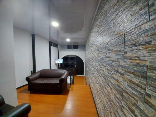 a living room with a leather couch and a wall at Apartaestudio2 Sector Cable-Estadio in Manizales