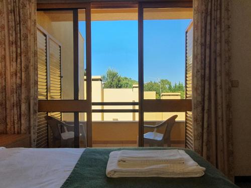 a bedroom with a bed and a window with a view at Tróia Beach Villa in Troia