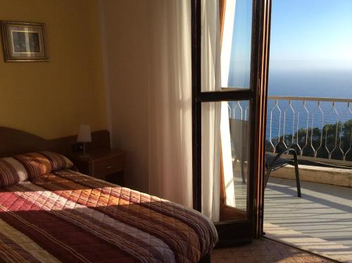 a bedroom with a bed and a door to a balcony at Hotel Due Gemelli in Riomaggiore