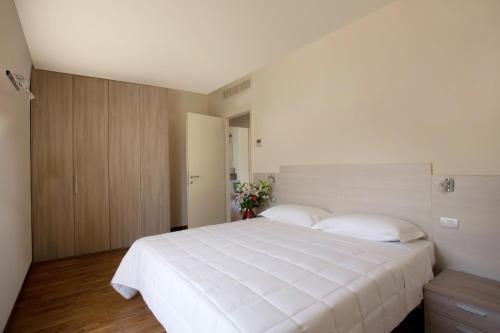 a bedroom with a large white bed in a room at Residence Le Querce in Cernusco sul Naviglio