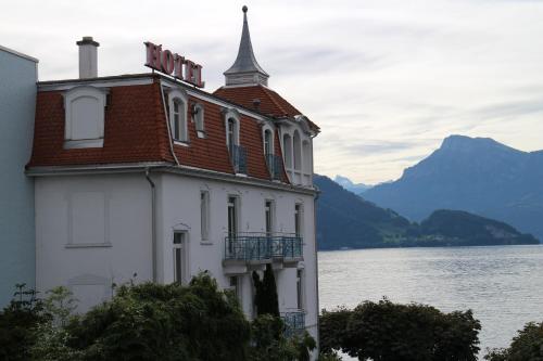 a building next to a body of water at Seminar-Hotel Rigi am See in Weggis