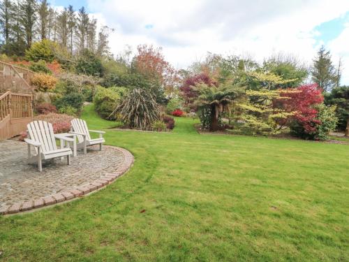 two chairs and a table in a yard at Lis-Ardagh Cottage 1 in Skahanagh