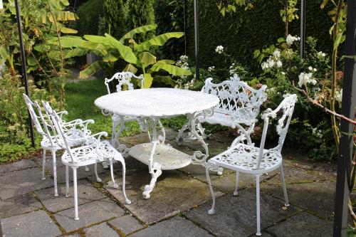 a white table and four chairs sitting around a table at Seminar-Hotel Rigi am See in Weggis