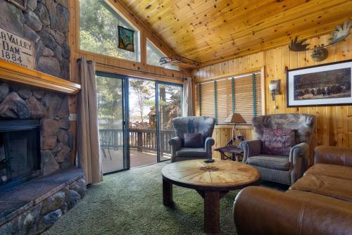 a living room with a fireplace and two chairs and a table at Lake Shore Family Cabin w Hot Tub and Pool Table by Big Bear Vacations in Big Bear Lake