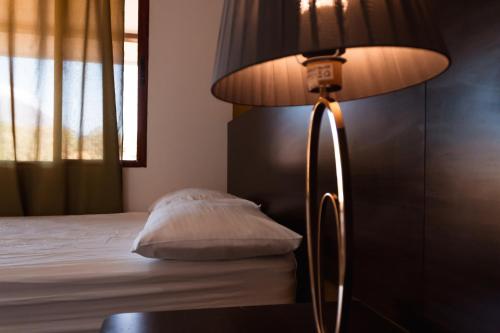 a lamp sitting next to a bed with a pillow at Hotel Boutique Victoria in Moyogalpa