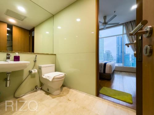 a bathroom with a toilet and a sink and a window at Soho suites klcc by Homestay in Kuala Lumpur