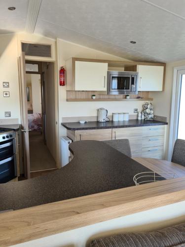 a kitchen with a table and a counter top at Beautiful 2 bedroom caravan, holiday park Tenby in Pembrokeshire