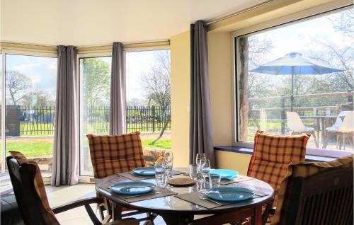 a dining room with a table and a large window at 3 Bedroom Amazing Home In La Hague in Vasteville