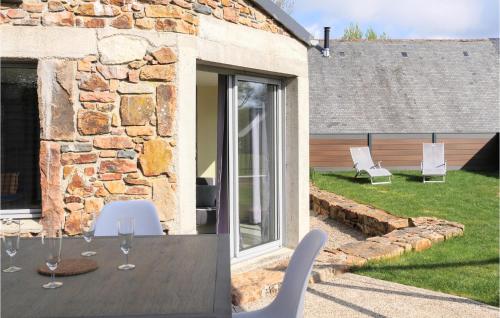 a patio with white chairs and a table with wine glasses at 3 Bedroom Amazing Home In La Hague in Vasteville