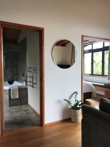 a living room with a mirror and a bathroom at Adrift In Golden Bay- Absolute Beachfront Villas in Collingwood