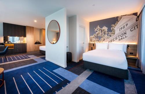 a hotel room with a bed and a desk at Novotel Melbourne Preston in Melbourne