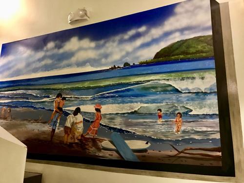 a painting of people on the beach on a wall at Playa Azul Baler in Baler