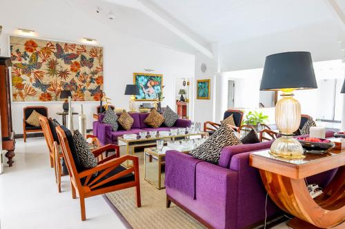 a living room with purple furniture and a purple couch at The Flame Tree Estate & Hotel in Kandy
