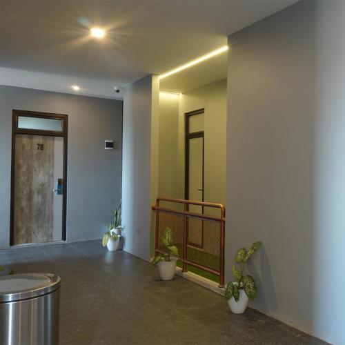 a hallway with potted plants in a building at Dparagon Menteng Jakarta in Jakarta