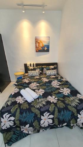 um quarto com uma cama com um cobertor estampado de flores em D'MANGO COTTAGE MELAKA HOMESTAY BANDAR HILIR DAN KLEBANG em Malaca