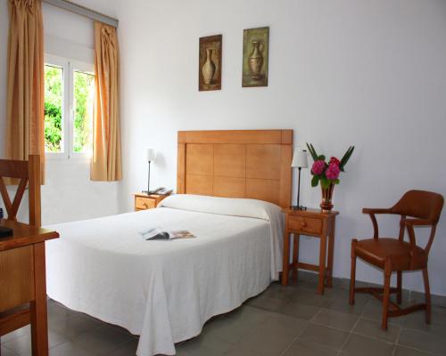 a bedroom with a bed and a table and a chair at Hotel Residencia Miami in Torremolinos