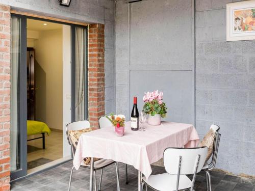 a table with flowers and wine bottles on a patio at Cozy Chalet with Garden in Beauraing
