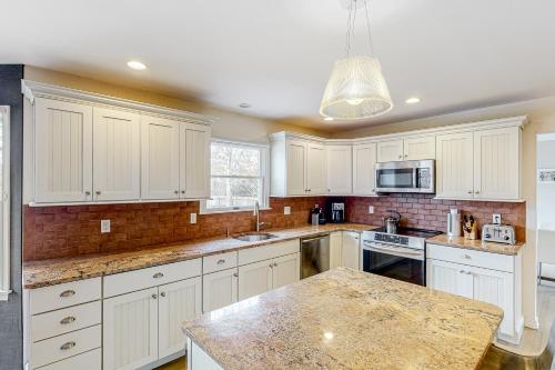 a kitchen with white cabinets and a granite counter top at Hamptons Hideaway in Hampton Bays