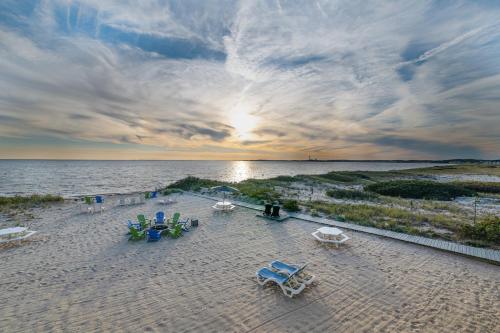 a view of a beach with chairs and tables at Sandbars Inn in North Truro