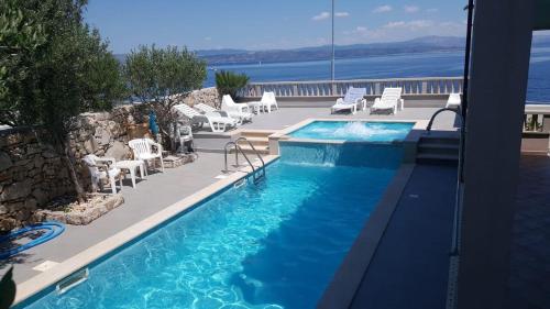 a swimming pool with a view of the water at Apartments Mlad - with pool in Rogač