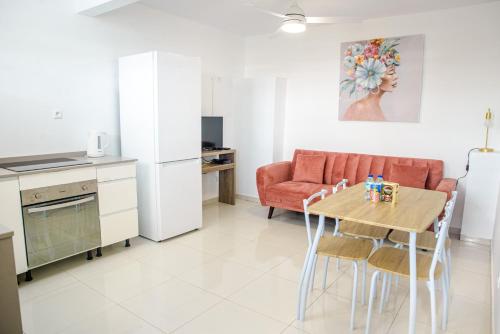 a kitchen and living room with a table and a couch at Suite jacuzzi et vue panoramique - BED AND COFFEE AIRPORT in Ducos