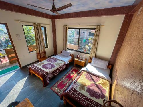 a room with two beds and a window at Hotel Hakoniwa in Pokhara