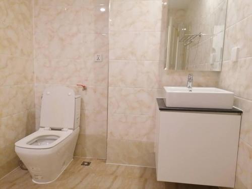 La salle de bains est pourvue de toilettes blanches et d'un lavabo. dans l'établissement Self-check-in private studio apartment, à Phnom Penh