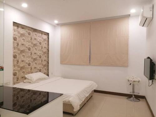 a bedroom with a bed and a wall with a tv at Self-check-in private studio apartment in Phnom Penh