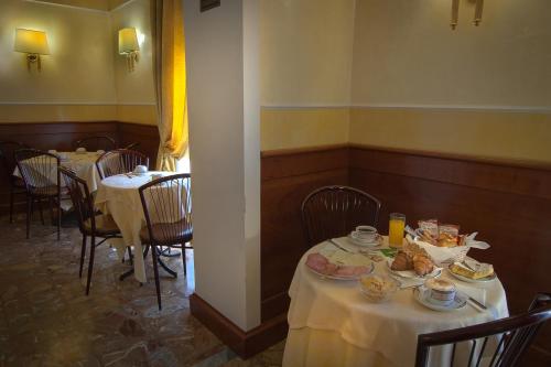 a dining room with two tables with plates of food at Hotel Miami in Rome