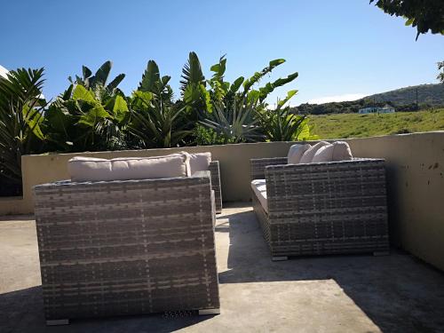 two wicker chairs are sitting on a patio at Sheep and Stars in Coffee Bay