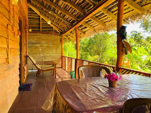 a patio with a table and chairs on a porch at Sigiri Lion Eco Palace in Sigiriya