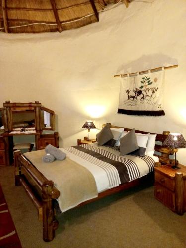 Deneysville的住宿－Brentwood Lodge，一间卧室配有一张床、两盏灯和一个架子
