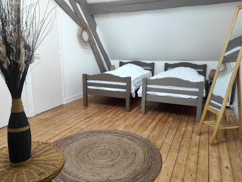 Zimmer mit 2 Betten, einem Tisch und einer Vase in der Unterkunft Gîte Mareuil-sur-Arnon, 4 pièces, 6 personnes - FR-1-586-22 in Mareuil-sur-Arnon