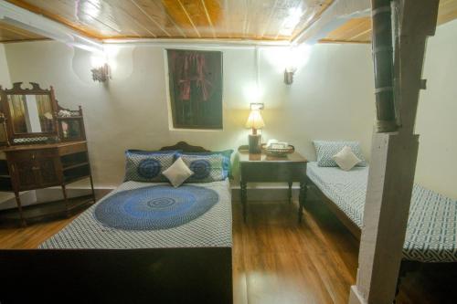 Habitación con 2 camas y mesa con lámpara. en Quo Vadis Farm, en Māngwa