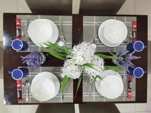 a glass shelf with plates and flowers on it at SG Resort Residences Kuantan by AP CA CON in Kampung Sungai Karang