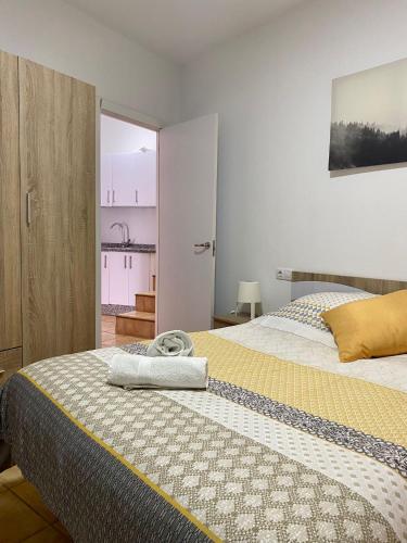 a bedroom with a bed with a yellow and white blanket at APARTAMENTO ARACENA RURAL in Aracena