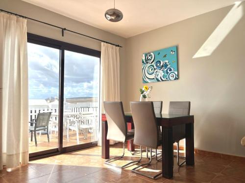 a dining room with a table and chairs and a balcony at Lanzarote Natura Houses in Soo