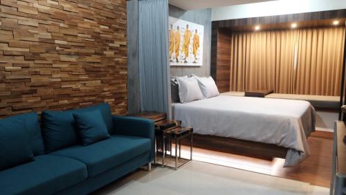 um quarto de hotel com uma cama e um sofá em Lavenderbnb Room 2 at Uttara the Icon Apartment em Yogyakarta
